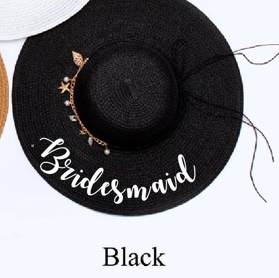 Black floppy hat with bridesmaid written in white with shell charms.